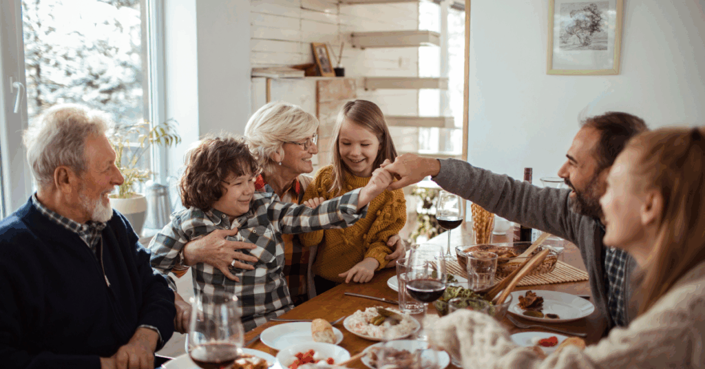 Family gathered around a Thanksgiving table sharing a warm meal, illustrating quiet wealth, gratitude, and family stewardship.