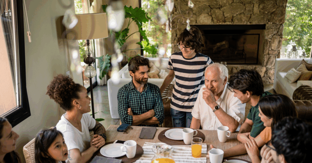 Multi-generation family talking around a breakfast table – parents supporting adult children financially while staying connected as a family.
