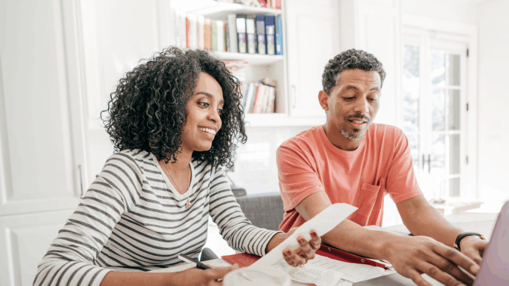 Couple reviewing charitable giving plan on a laptop, discussing donor-advised funds and tax-efficient philanthropy at home.